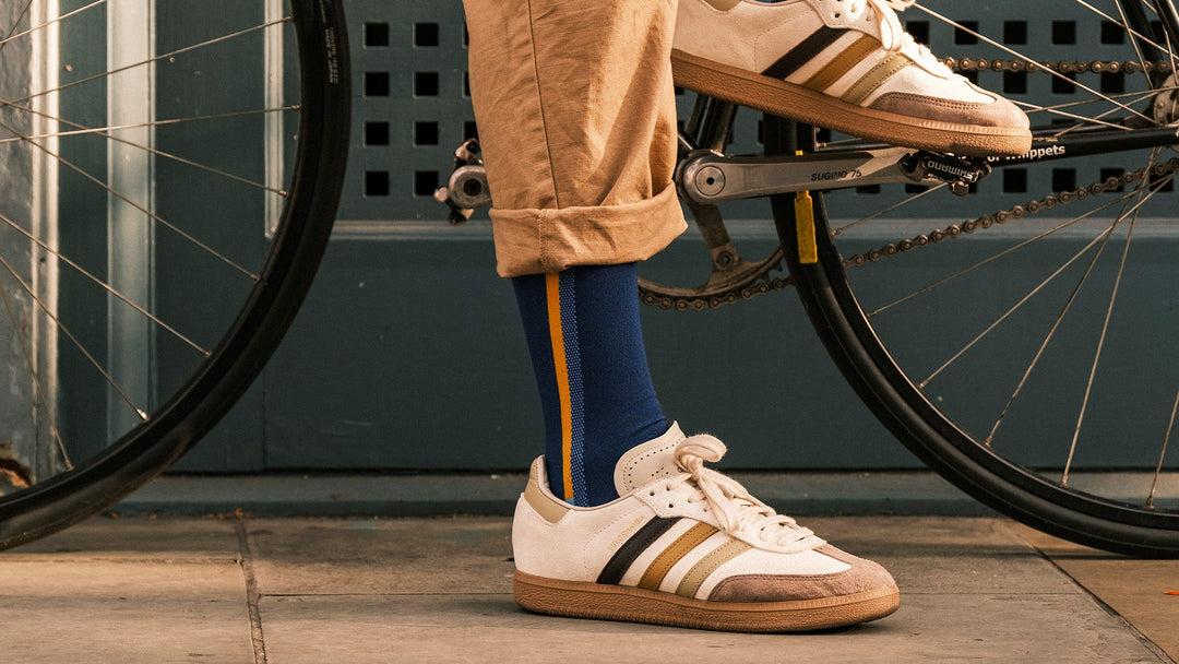 Cyclist wearing blue and orange QEJA performance socks